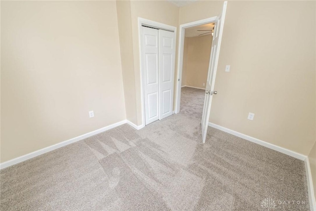 unfurnished bedroom featuring light colored carpet and a closet