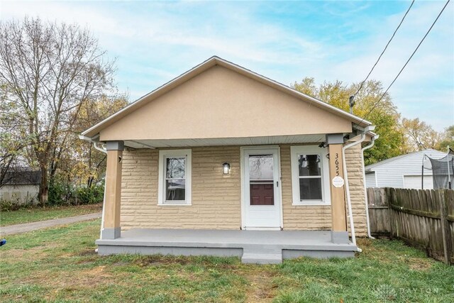 rear view of house with a lawn and covered porch