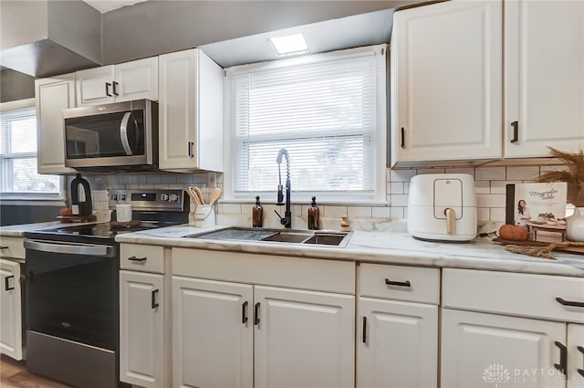 kitchen with white cabinetry, appliances with stainless steel finishes, and plenty of natural light