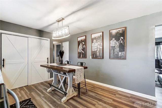 dining area with dark hardwood / wood-style flooring and a chandelier