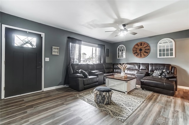 living room featuring ceiling fan and dark hardwood / wood-style floors