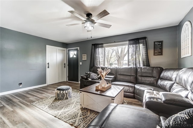 living room featuring wood-type flooring and ceiling fan