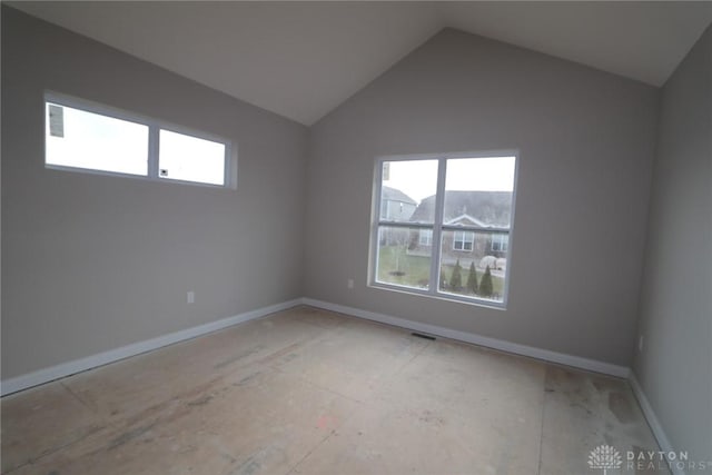 unfurnished room with a healthy amount of sunlight and vaulted ceiling