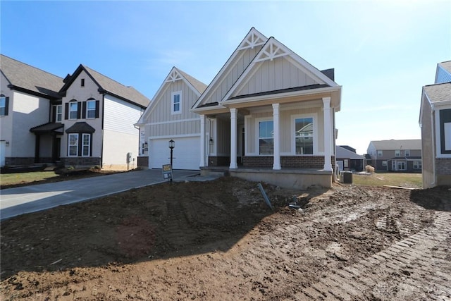 view of front facade featuring board and batten siding, a residential view, covered porch, and concrete driveway