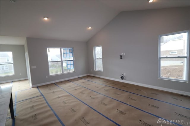 unfurnished room with vaulted ceiling and a healthy amount of sunlight