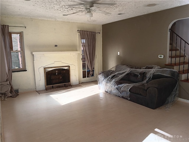 living room featuring ceiling fan and a textured ceiling