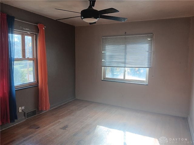 unfurnished room featuring hardwood / wood-style flooring, a wealth of natural light, and ceiling fan