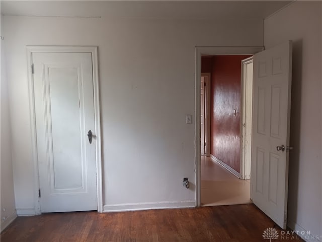 unfurnished bedroom with dark wood-type flooring