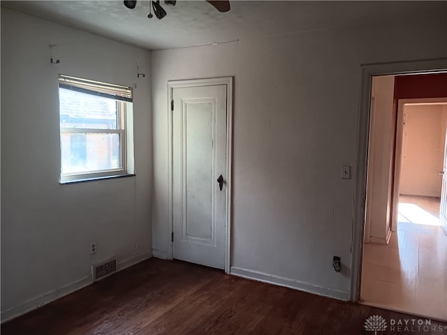 unfurnished bedroom featuring ceiling fan and dark hardwood / wood-style floors