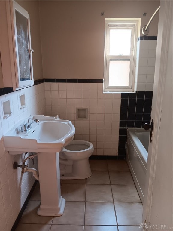 full bathroom featuring toilet, tile walls, tile patterned flooring, sink, and shower / tub combination