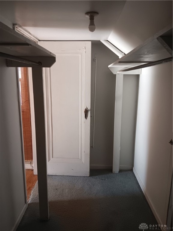 corridor with vaulted ceiling and carpet floors