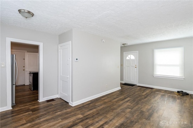 entrance foyer featuring a textured ceiling and dark hardwood / wood-style flooring