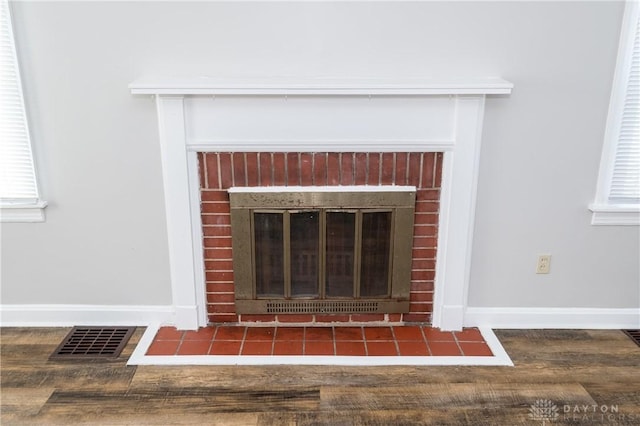 interior details featuring a brick fireplace and hardwood / wood-style flooring