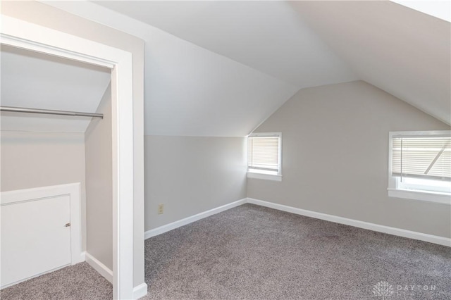 bonus room with plenty of natural light, light colored carpet, and vaulted ceiling