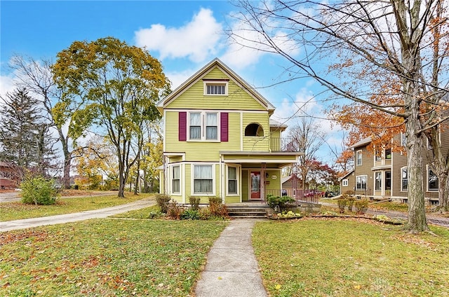 victorian house with a front yard and covered porch