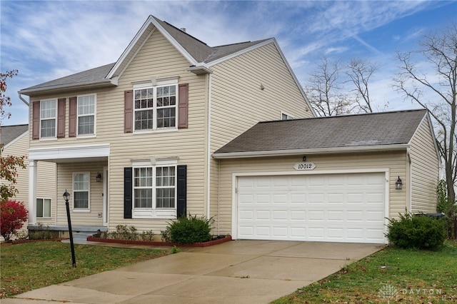 view of front facade with driveway, an attached garage, and a front lawn