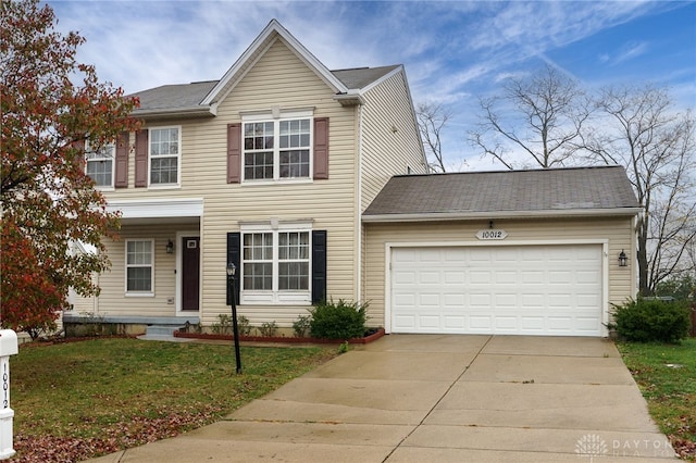 traditional-style house with driveway, a front lawn, and an attached garage