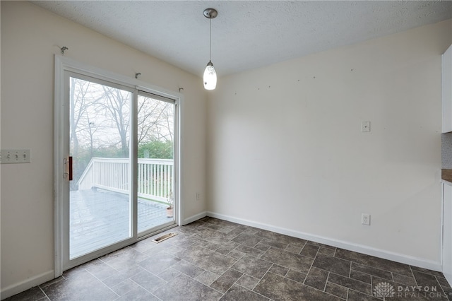 spare room with a textured ceiling, visible vents, and baseboards