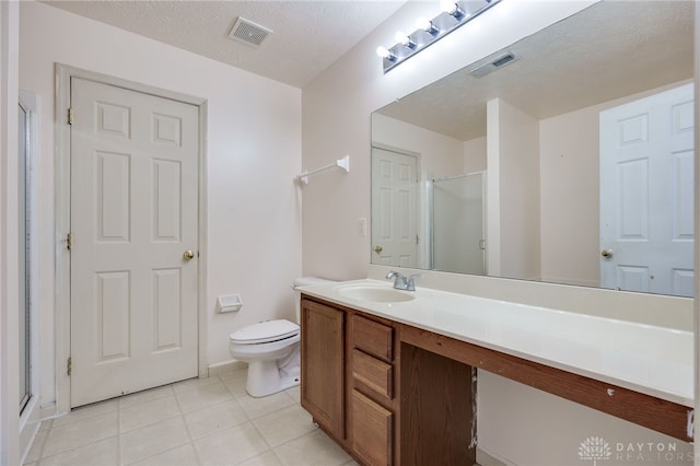 bathroom featuring a textured ceiling, toilet, a shower stall, and visible vents