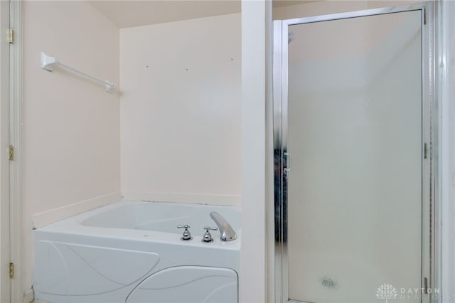 bathroom featuring a garden tub and a shower stall