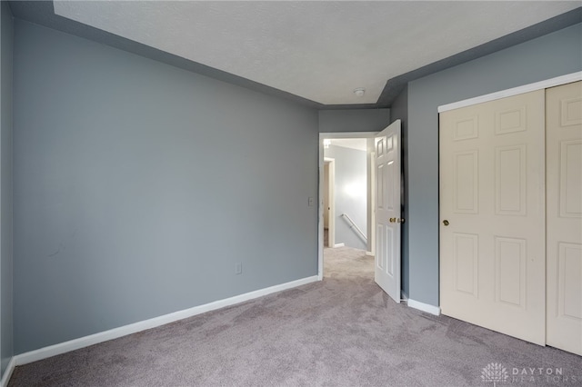 unfurnished bedroom featuring carpet and baseboards