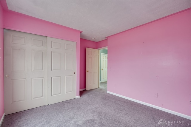 unfurnished bedroom featuring a closet, carpet flooring, and baseboards