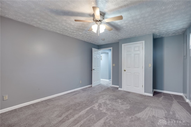 unfurnished bedroom featuring carpet floors, ceiling fan, baseboards, and a textured ceiling