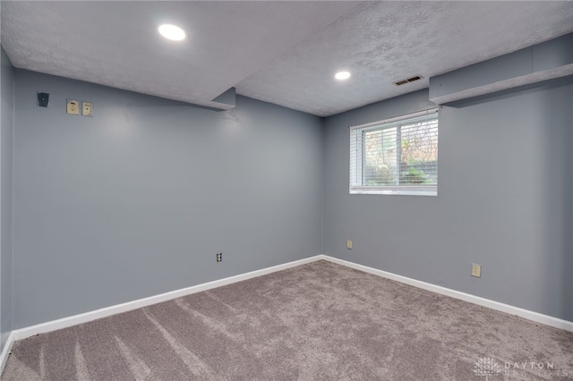 basement with recessed lighting, carpet flooring, a textured ceiling, and baseboards