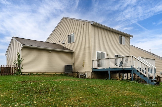 rear view of house featuring cooling unit, a lawn, a deck, and fence