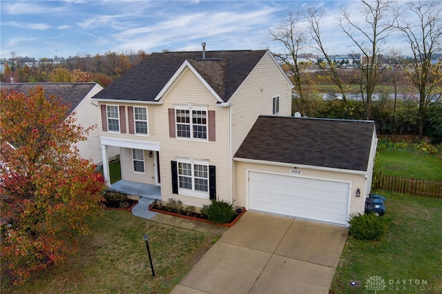 traditional home with concrete driveway, covered porch, an attached garage, a front yard, and fence