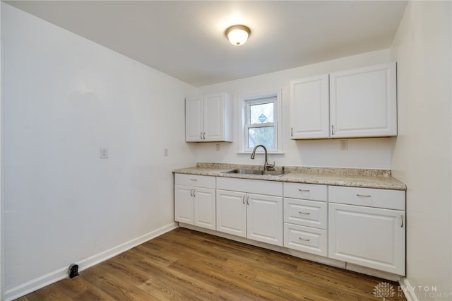 kitchen with white cabinets, sink, and hardwood / wood-style floors