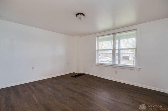 spare room with dark wood-type flooring