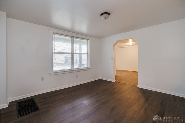 unfurnished room with dark wood-type flooring