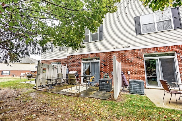 rear view of house with central AC unit and a patio