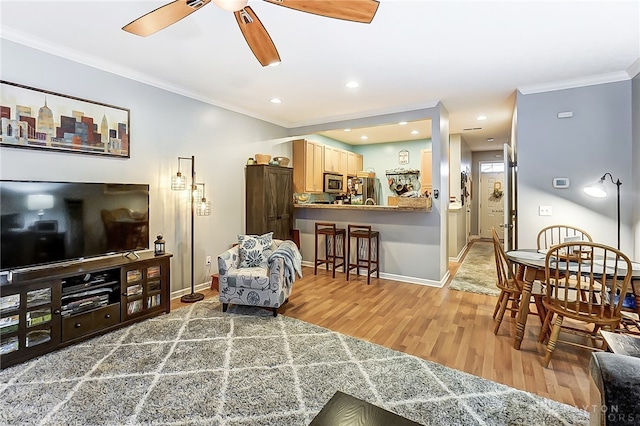 living room featuring hardwood / wood-style flooring, ceiling fan, and crown molding