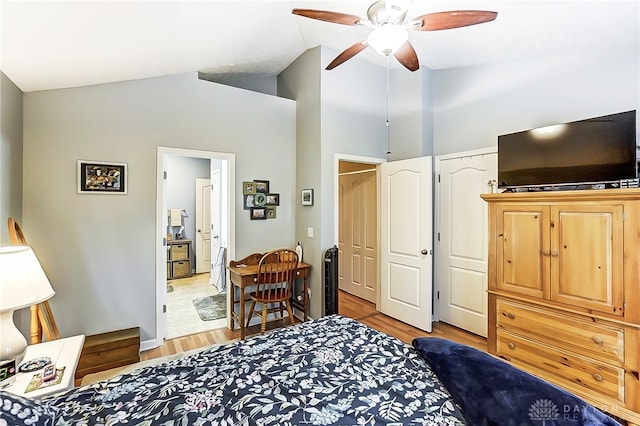 bedroom featuring a closet, ensuite bath, high vaulted ceiling, ceiling fan, and light hardwood / wood-style flooring