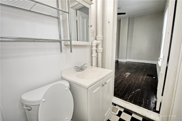 bathroom featuring wood-type flooring, vanity, and toilet