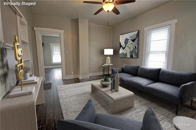 living room with dark wood-type flooring and ceiling fan