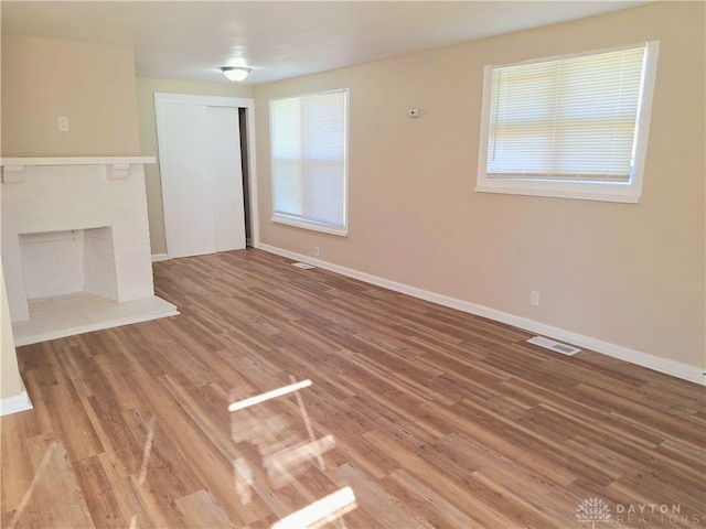 unfurnished living room with a fireplace and wood-type flooring