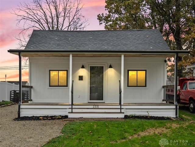 bungalow-style house featuring a porch and roof with shingles