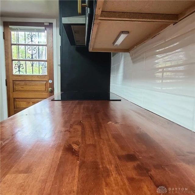 unfurnished room featuring wood-type flooring and beam ceiling