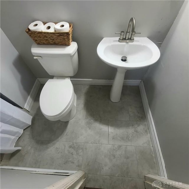 bathroom with toilet and tile patterned floors