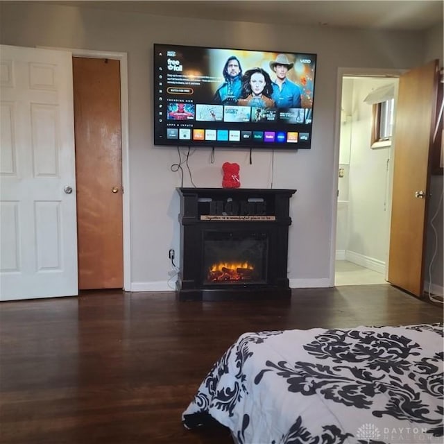 bedroom with ensuite bathroom and dark hardwood / wood-style flooring