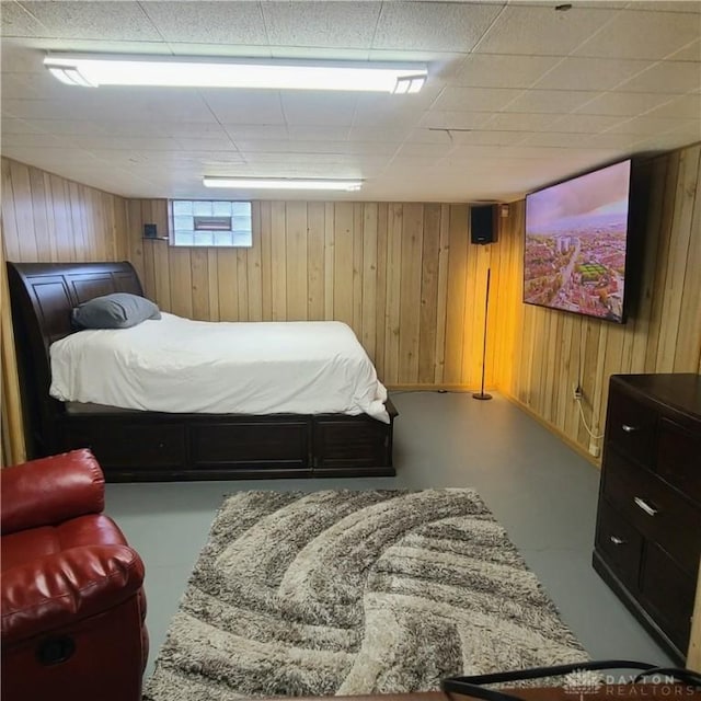 bedroom with concrete floors and wooden walls