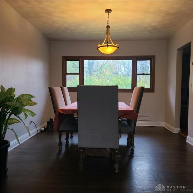 dining area featuring baseboards and dark wood-style flooring