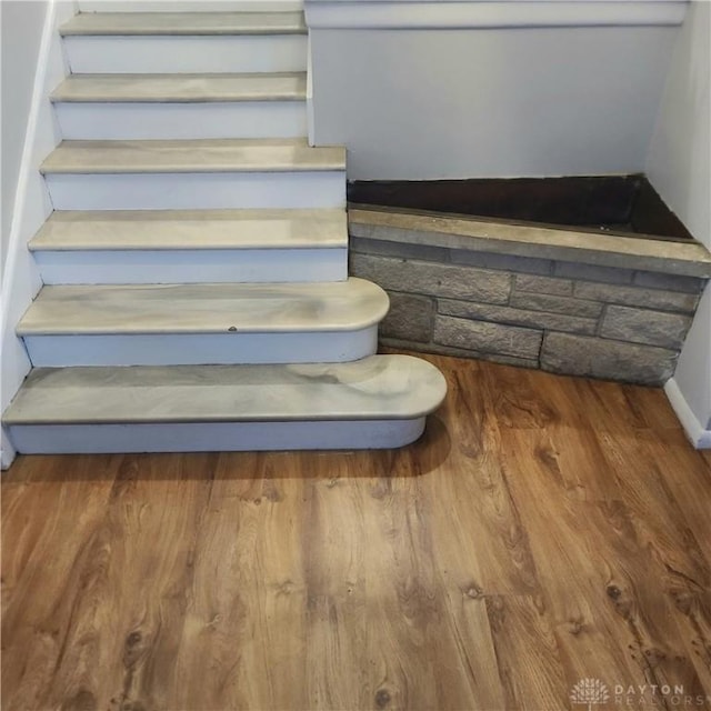 stairway featuring baseboards and wood finished floors