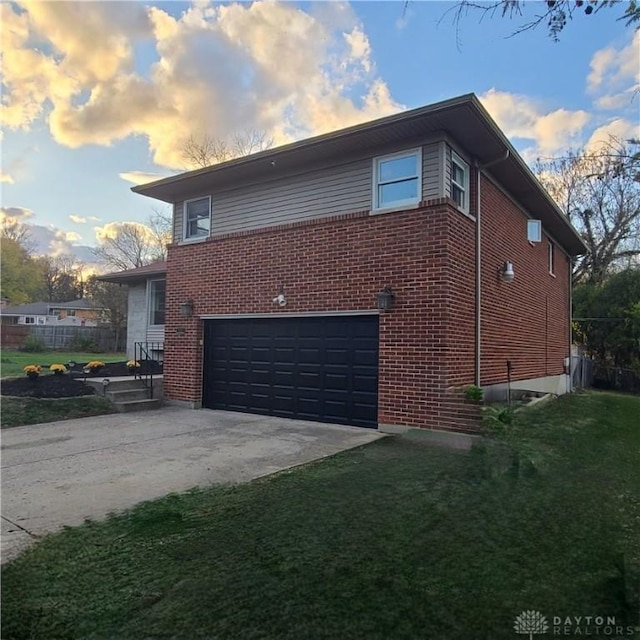 property exterior at dusk with a garage and a lawn