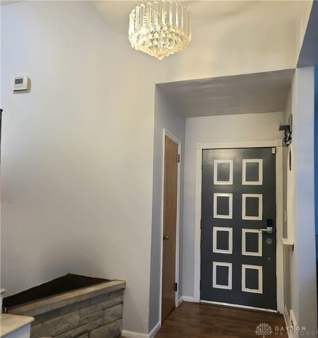 doorway to outside with dark hardwood / wood-style flooring and a notable chandelier