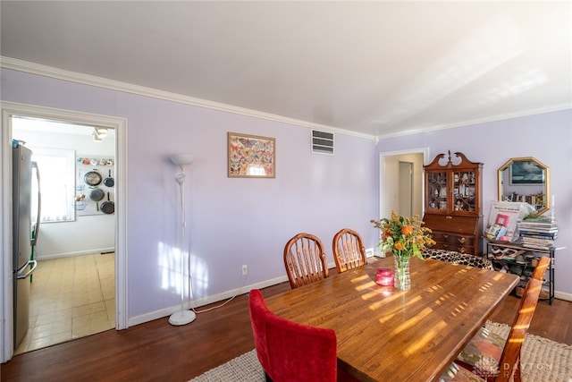 dining area featuring ornamental molding and dark hardwood / wood-style floors