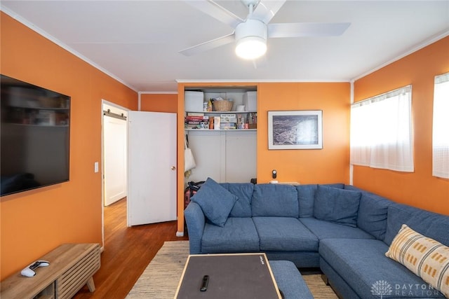 living room featuring ceiling fan, ornamental molding, and dark hardwood / wood-style flooring